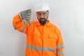 Man wearing hardhat, safety goggles and reflecting jacket, with angry face, negative sign showing dislike with thumbs d