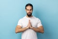 Man concentrating his mind, keeping hands namaste gesture meditating, yoga exercise breath technique