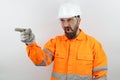 Man wearing worker uniform and hardhat pointing with finger screming and shouting with angry face Royalty Free Stock Photo