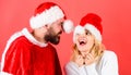 Man with beard and woman santa hat red background. Couple cheerful face celebrate christmas. Rent santa costume. Couple