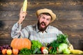 Man with beard wooden background. Become organic farmer. Farmer with organic homegrown vegetables. Grow organic crops