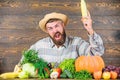 Man with beard wooden background. Become organic farmer. Farmer with organic homegrown vegetables. Grow organic crops