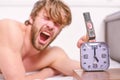 Man bearded annoyed sleepy face lay pillow near alarm clock. Break discipline regime. Stop ringing. Annoying sound Royalty Free Stock Photo