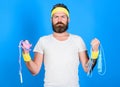 Man bearded athlete hold jump rope and tape measure. Athlete guide stay in shape. Old school aerobics concept. Athlete