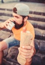 Man bearded bite tasty sausage and drink paper cup. Street food so good. Urban lifestyle nutrition. Carefree hipster eat