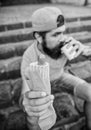 Man bearded bite tasty sausage and drink paper cup. Street food so good. Urban lifestyle nutrition. Carefree hipster eat