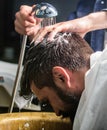 Man bearded client of hipster barbershop. Barbers hands washing hair of bearded hipster. Barbershop concept. Man with Royalty Free Stock Photo