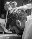 Man bearded client of hipster barbershop. Barbers hands washing hair of bearded hipster. Barbershop concept. Man with Royalty Free Stock Photo