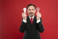 Man bearded consultant formal suit hold light bulb on red background. Symbol of idea progress and innovation Royalty Free Stock Photo