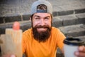 Man bearded eat tasty sausage and drink paper cup. Urban lifestyle nutrition. Junk food. Carefree hipster eat junk food Royalty Free Stock Photo