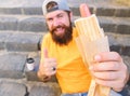 Man bearded enjoy street food stairs background. Hipster eat hot dog and drink coffee. Lunch time concept. Hipster enjoy Royalty Free Stock Photo