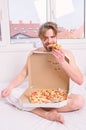 Man bearded handsome eat pizza. Man eat pizza breakfast. Guy naked covered pizza box sit bed bedroom offer you join him Royalty Free Stock Photo