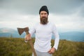 Man bearded hipster with axe stand on mountain landscape Royalty Free Stock Photo