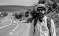 Man bearded hipster backpacker at edge of highway. Take me with you. Traveler waiting for car take him anyway just to Royalty Free Stock Photo