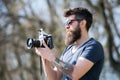 Man bearded hipster photographer hold vintage camera. Photographer with beard and mustache amateur photographer nature