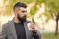 Man bearded hipster prefer coffee take away. Businessman drink coffee outdoors. Reloading energy. Relaxing coffee break Royalty Free Stock Photo