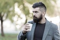 Man bearded hipster prefer coffee take away. Businessman drink coffee outdoors. Reloading energy. Relaxing coffee break Royalty Free Stock Photo