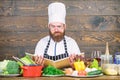 Man bearded hipster read book recipe near table fresh vegetables. Culinary arts. Recipe to cook healthy food. Vegetarian Royalty Free Stock Photo