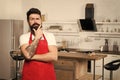 Man bearded hipster red apron stand in kitchen. Kitchen furniture store. Cooking in new kitchen. Need culinary