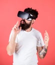 Man bearded hipster with virtual reality headset on red background. Shooting gallery VR. First person shooter shows how Royalty Free Stock Photo