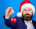 Man bearded hipster wear formal suit and santa hat. Special christmas offer. Santa hold christmas ball decoration