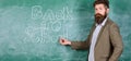 Man bearded teacher missed his work during vacation. Back to school concept. Teacher near chalkboard holds chalk write Royalty Free Stock Photo