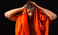 Man bearded tousled hair covered with foam soap suds. Wash off foam with water carefully. Man with orange towel wipe