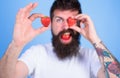 Man bearded winking with red berry, defocused. Perfect strawberry concept. Look at my berry. Man handsome hipster long