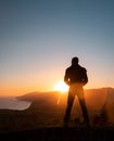 Man in beautiful inspiring sunrise with mountains and sea. Royalty Free Stock Photo