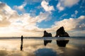 A man with the beautiful Wharariki Beach with famous rocks. Sunset scene golden light and silhouette. Nelson, South Island, New Royalty Free Stock Photo