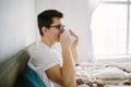 Man in bed drinking morning coffee in sunrise light Royalty Free Stock Photo