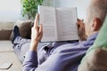 Man in bed reading book at home Royalty Free Stock Photo