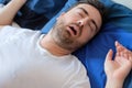 Man in bed suffering for sleep apnea syndrome