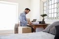 Man In Bedroom Running Business From Home Dispatching Goods Royalty Free Stock Photo