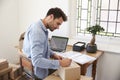 Man In Bedroom Running Business From Home Labeling Goods