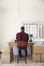 Man In Bedroom Running Business From Home Labeling Goods Royalty Free Stock Photo