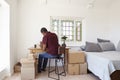 Man In Bedroom Running Business From Home Labeling Goods