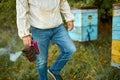 Man beekeeper working in apiary, using bee smoker Royalty Free Stock Photo