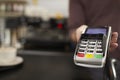 Man behind cafe counter offers credit card reader, close up Royalty Free Stock Photo