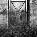 Man behind vintage metal door and overgrown plants