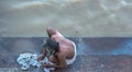 Man from behind washing clothes in the river Ganges, in Varanasi, India. Aerial photo