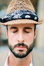 Man in a beige hat with his eyes closed. Portrait