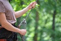 Man belays his partner climber with belaying device and rope. Climber`s handsman holding equipment for rock mountaineering