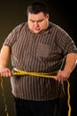 Man belly fat with tape measure weight loss around body . Royalty Free Stock Photo