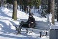 Man on a bench in the park. Cold morning. Man winter. Man on the bench. Winter road. Road with bench. Sunny Winter morning. Royalty Free Stock Photo