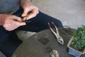 A man bending a wire for repotting bonsai