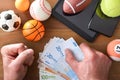 Man betting online with devices on wooden table and objects Royalty Free Stock Photo