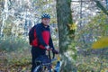 A man with a Bicycle in the autumn forest, an elderly cyclist in a helmet