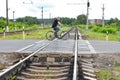 Man on bicycle crosses a railway crossing, bicycle pedal on rails. Royalty Free Stock Photo