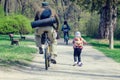 Belaya Tserkov, Ukraine - April 21, 2019: A man on a bicycle and a little girl on a scooter ride in the spring park Royalty Free Stock Photo